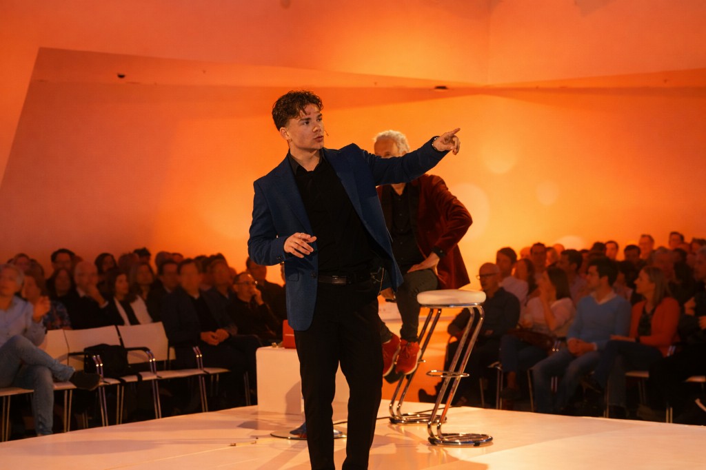 Umely spreker wijst naar het publiek tijdens een AI-presentatie