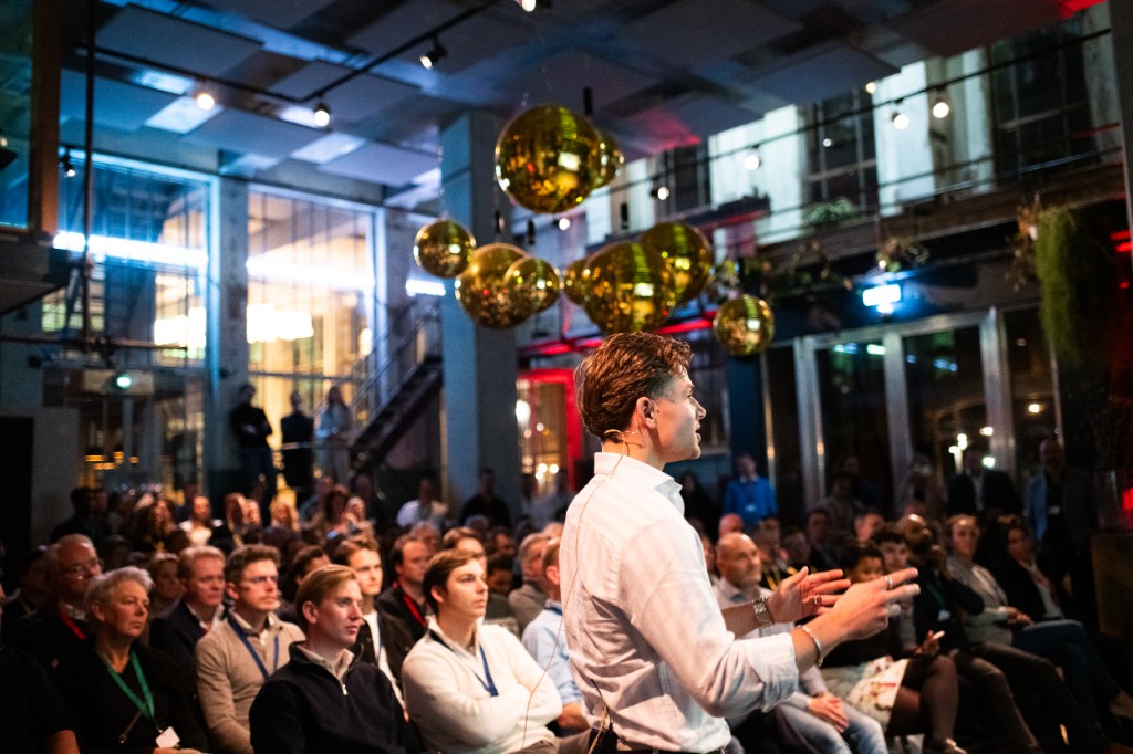 Spreker voor publiek in een moderne evenementenlocatie