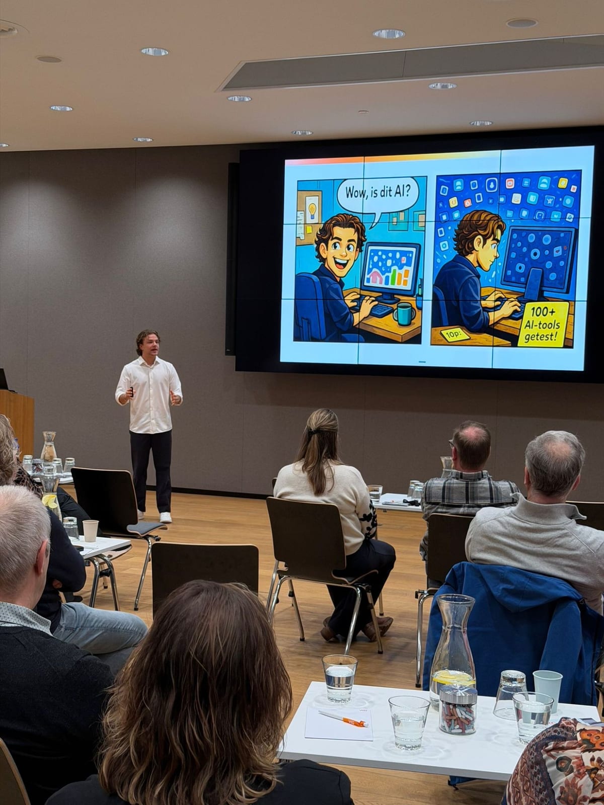 Deelnemers kijken naar een scherm met een illustratie over honderd geteste AI-tools